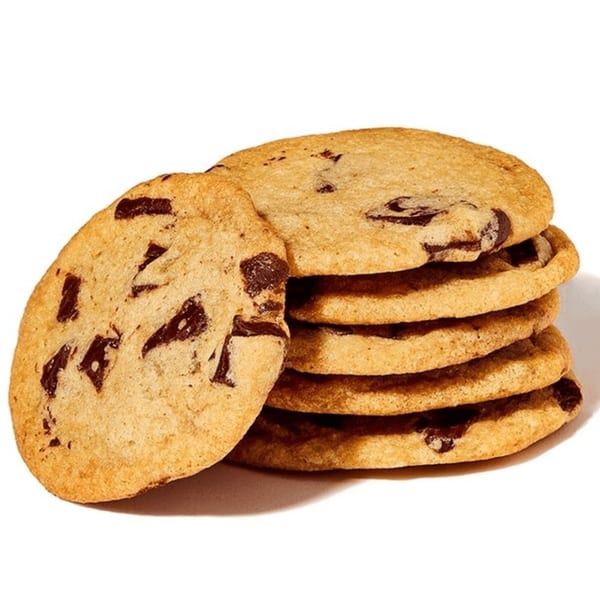 A stack of five chocolate chip cookies with one leaning against the side, on a white background.
