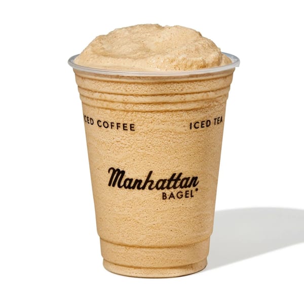 A Manhattan Bagel frozen coffee drink in a clear plastic cup with the logo visible.