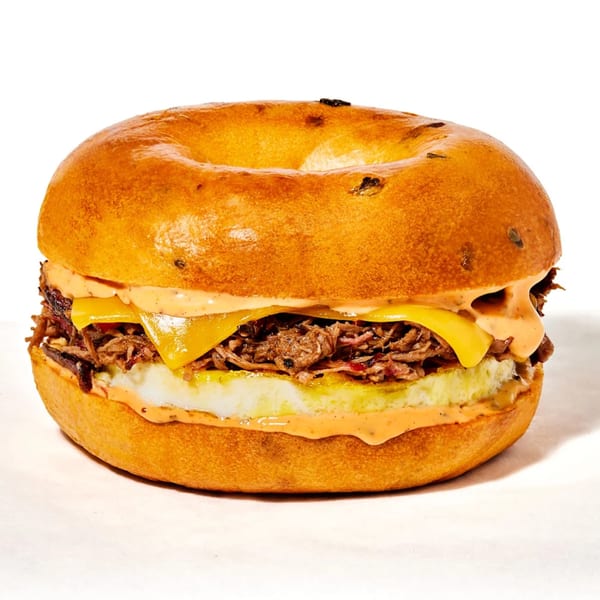 Manhattan Bagel's breakfast sandwich with egg, cheese, and shredded meat on a golden bagel.
