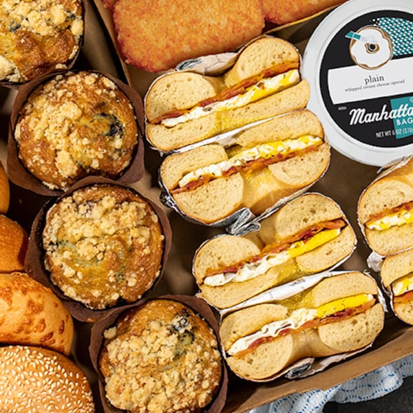 Manhattan Bagel breakfast box with muffins, hash browns, bagel sandwiches, and cream cheese.
